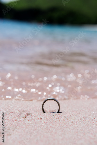 Wedding ring on the sand of Pink Beach