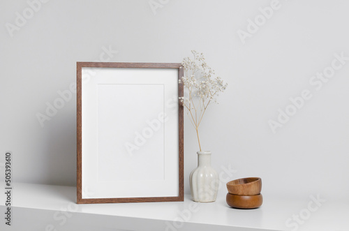 Vertical frame mockup in white minimalistic interior with flowers decorations
