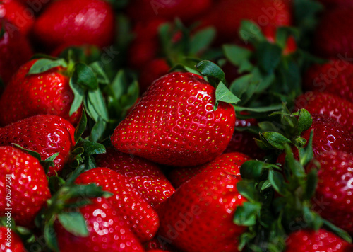 Close-up of a selective focus of ripe strawberries on the counter. Strawberries are sold in boxes as a healthy food. Top view of delicious, fresh, juicy strawberries, just picked. Juicy berries.