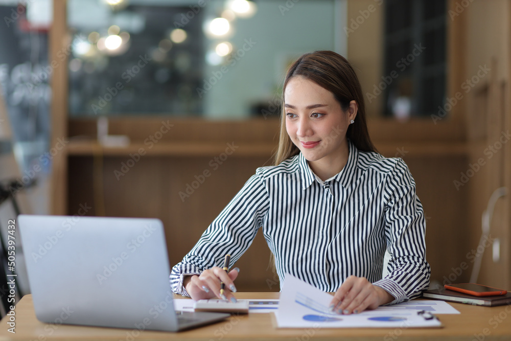 Business woman working on financial documents and calculating accounting using calculator and laptop. Business woman working on financial documents and calculating accounting using calculator and laptop.
