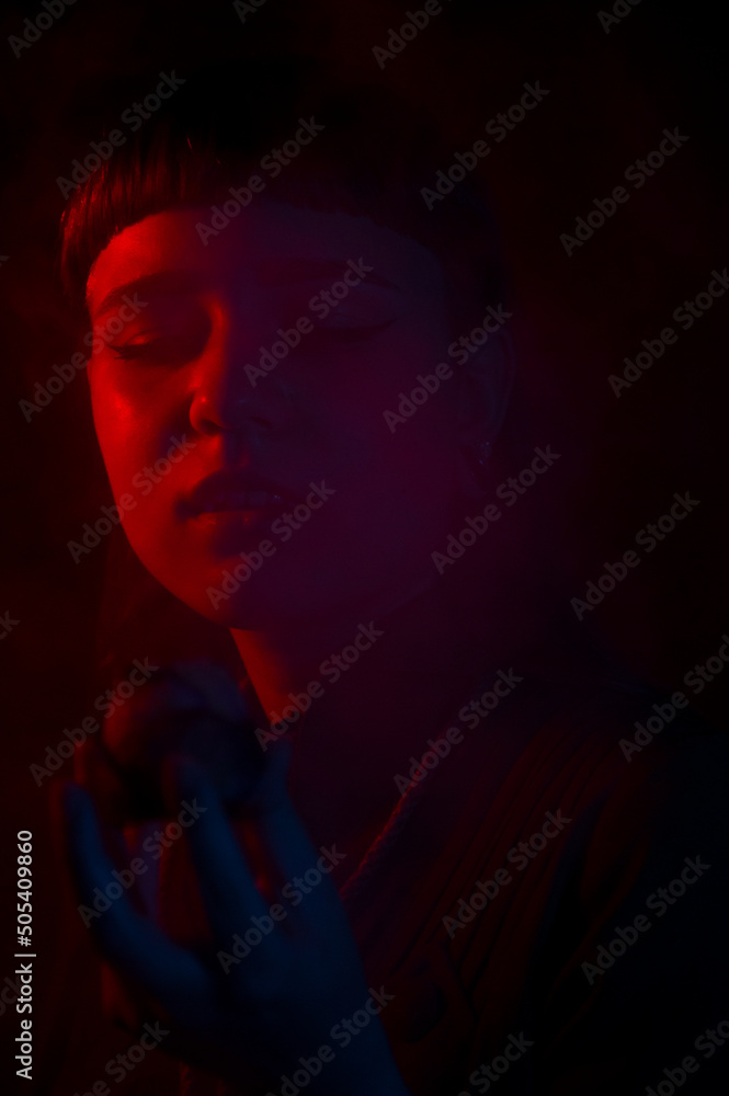 A gothic girl smoking a flower pipe with smoke and dark background