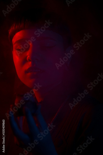 A gothic girl smoking a flower pipe with smoke and dark background