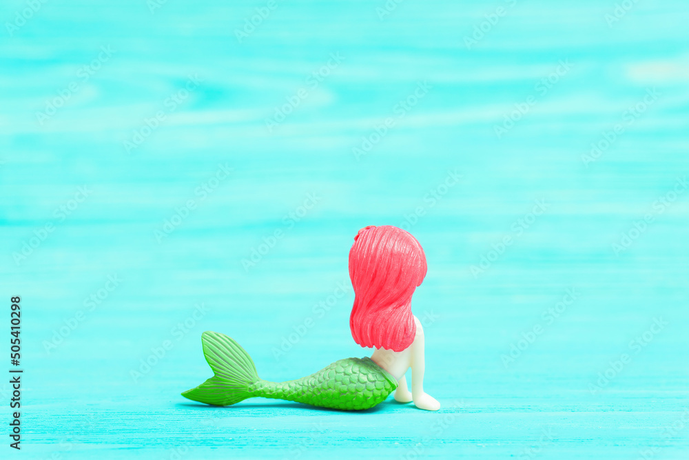 Mermaid figurine on a turquoise background Mermaid figurine on a turquoise background