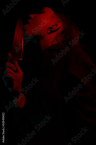 A gothic girl with a knife in smoke with dark background