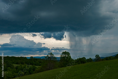 Mountain landscape with dramatic stormy clouds during the rain