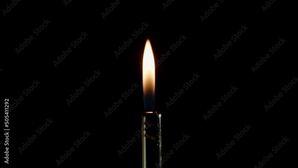 Lighting fire with lighter on dark background. Gas Lighter Gun Lighting fire with lighter on dark background. Gas Lighter Gun