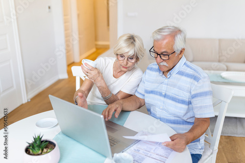 Senior couple is talking online via video connection on the laptop. Having nice time withfriends and family via video call. photo