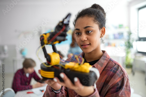 College student holding her robotic toy at robotics classroom at school. photo