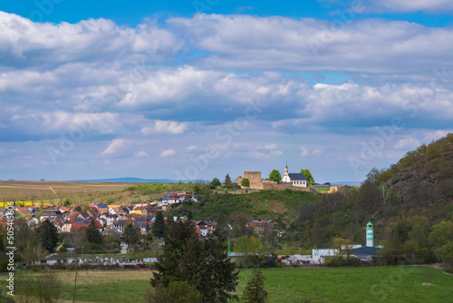 View across meadows to the village of Neu Bamberg/Germany in Rheinhessen with its castle ruins and St. Dionysius Church