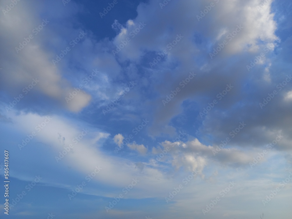 gray stratocumulus cloud and cirrus cloud with blue sky