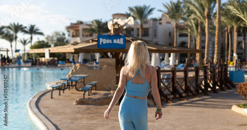 Outdoor shot of fit young woman in sports bra standing at the poolside. © Angelov