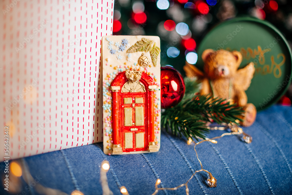 Φωτογραφία A beautifully decorated Christmas treat shaped like a cottage, placed near a sparkling tree