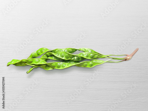 Petai or bitter beans or stinky beans on white wooden table background photo