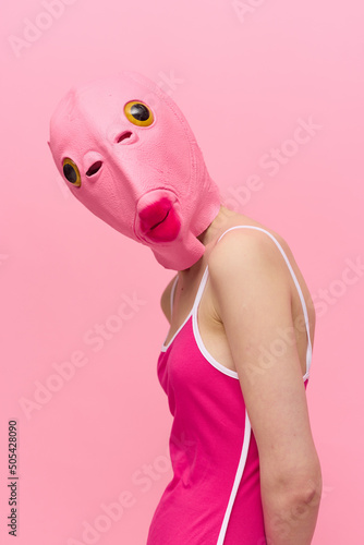 Konstfotografi A woman wearing a silicone Halloween mask in the shape of a pink fish with big y