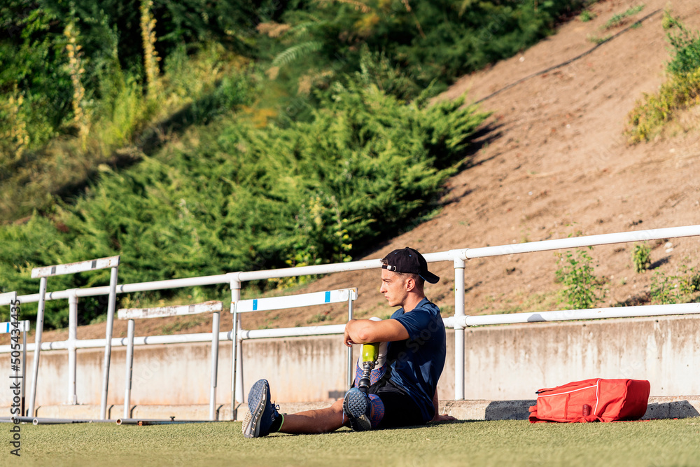 Fototapeta premium Disabled man athlete stretching with leg prosthesis.