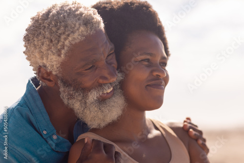 Close-up of smiling bearded african american senior man and mature woman with afro hair looking away
