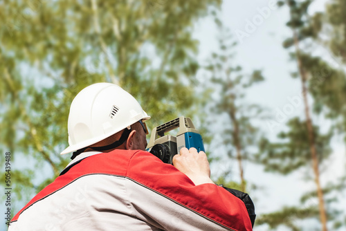 Construction of a residential area. Geodetic stakeout. Surveyor at a large construction site. A man with a tachometer during work. Makshader. photo