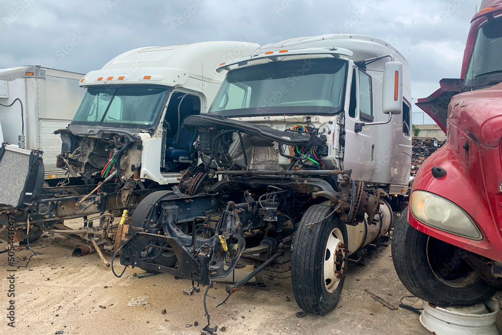 Three broken trucks in junk yard after accident, discarded salvage cars with crashed engines. Outdoor park with automobile wreckage parts debris Three broken trucks in junk yard after accident, discarded salvage cars with crashed engines. Outdoor park with automobile wreckage parts debris