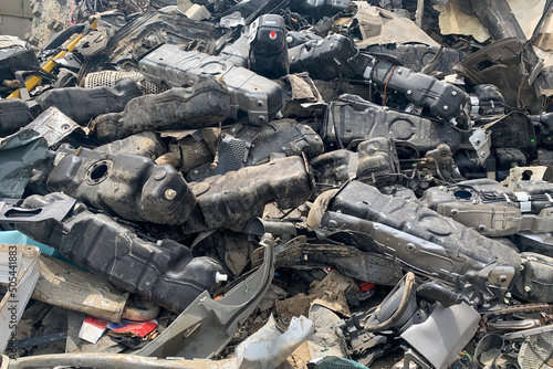 A lot of fuel tanks of broken automobiles, used auto spare parts for reuse, spare parts from damaged vehicles on junk yard or car dump