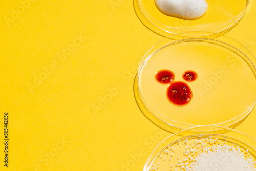 Cosmetic swatches. Appearance of the texture of the red mask, foam and granules in petri dish on a yellow background. Natural skincare products. Beauty concept for face and body care