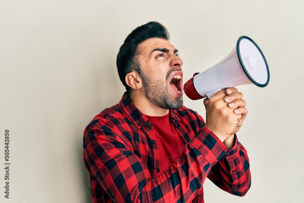 Photography Hispanic man with beard screaming with megaphone
