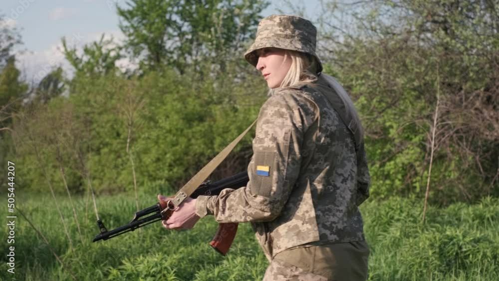 Young Ukrainian female soldier in camouflage uniform with an assault ...