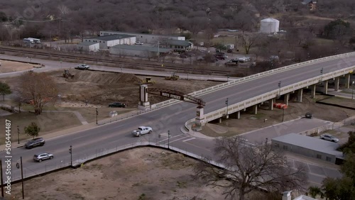Aerial follow shot of cars passing over Mays Street bridge near downtown Round Rock, Texas. photo