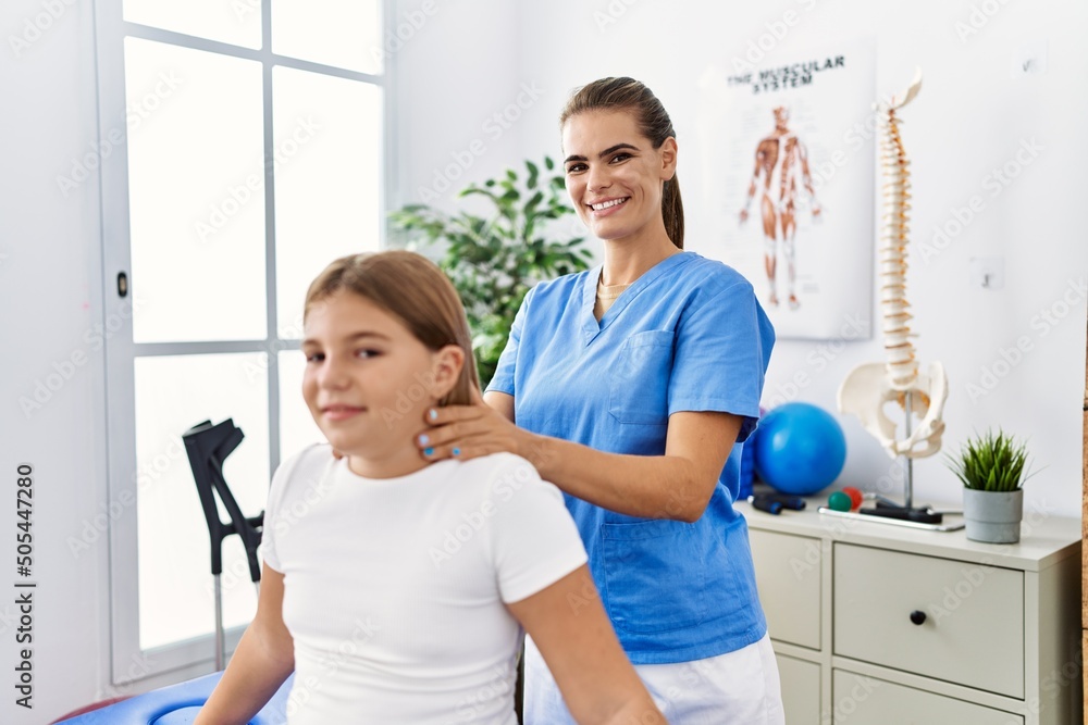 Obraz premium Woman and girl physiotherapist and patient having rehab session massaging neck at physiotherapy clinic