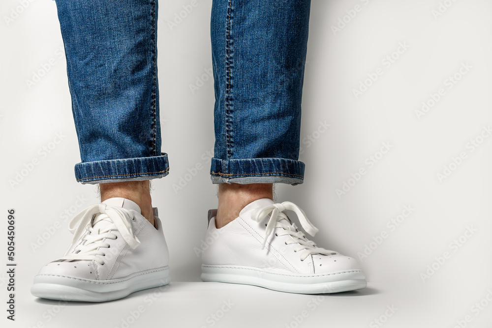 Man in Stylis New White Sneakers and jeans Over White Background. Horizontal Image
Man in Stylis New White Sneakers and jeans Over White Background. Horizontal Image