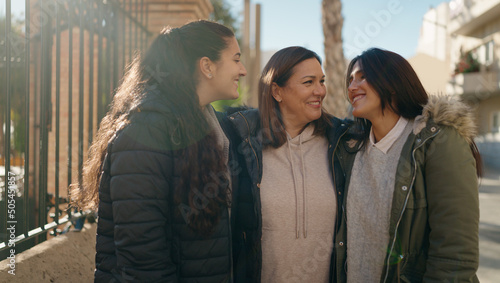 Mother and daugthers smiling confident hugging each other at street photo