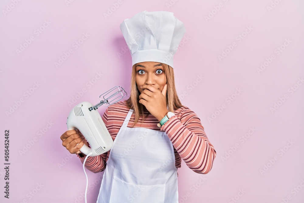 Φωτογραφία Beautiful hispanic woman holding pastry blender electric mixer shocked covering mouth with hands for mistake