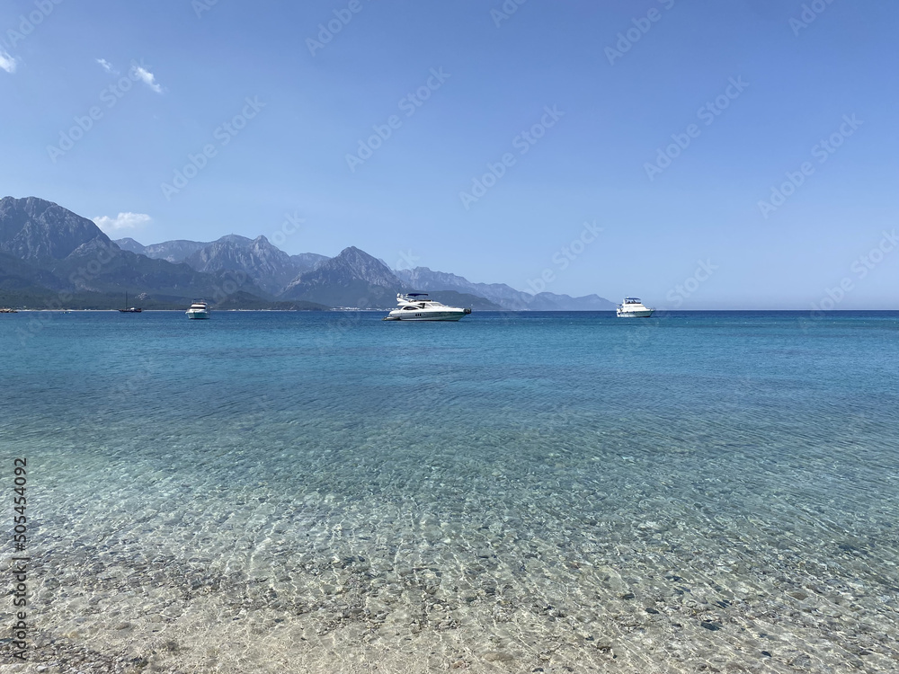 Yacht on the shore of the cozy bay, near Antalya and Kemer, Turkey on the Mediterranean coast. Beach and tourist destination. Picturesque Mediterranean seascape in Turkey. 