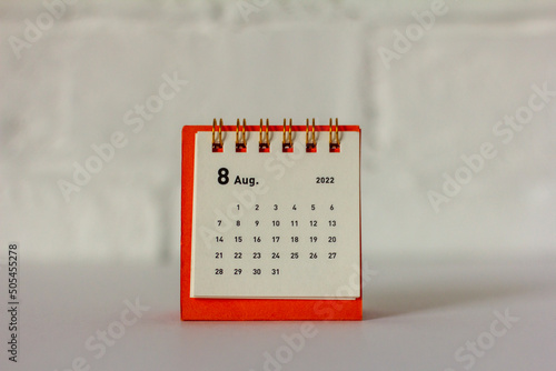 Desktop mini calendar for August 2022 on the table.