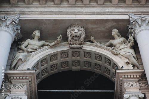 Sculptures of two muses with lyre and paper with pen as allegories of the arts. The head of a lion on the facade of the Opera and Ballet Theater in Lviv. Neo-Renaissance in architecture. photo