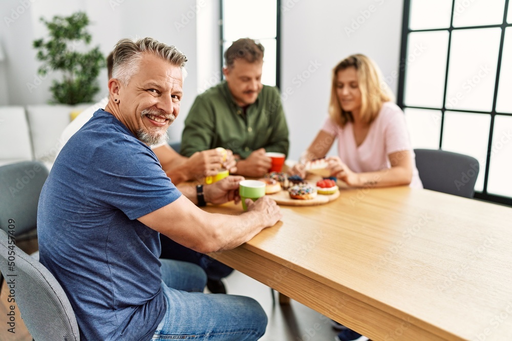 Group of middle age friends having breakfast sitting on the table at home. Group of middle age friends having breakfast sitting on the table at home.