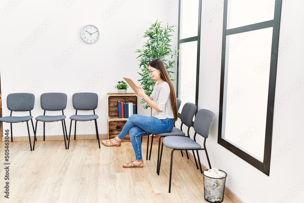 Young asian woman with checklist at waiting room Young asian woman with checklist at waiting room