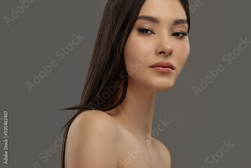 Young beautiful asian beauty model on a gray isolated background.
