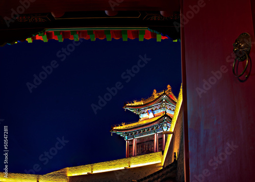 Facade of an illuminated Buddhist temple against a night sky photo