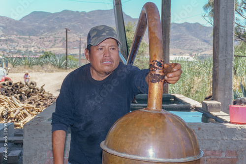 master mezcalero distilling mezcal in oaxaca photo