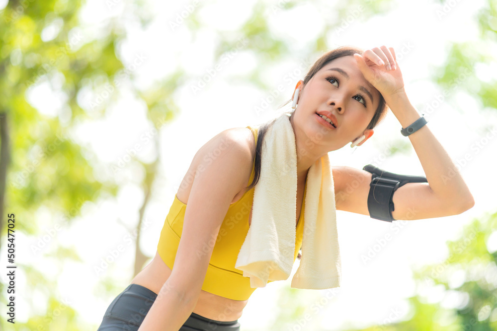 Asian active Female runner workout standing bent over and catching her breath after a running session in the park garden. Sports female woman taking break after a run in morning exercise lifestyle Asian active Female runner workout standing bent over and catching her breath after a running session in the park garden. Sports female woman taking break after a run in morning exercise lifestyle