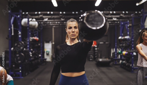 Young woman exercising with a dumbbell at the gym