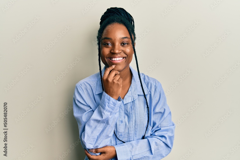Φωτογραφία African american woman with braided hair wearing casual blue shirt smiling looking confident at the camera with crossed arms and hand on chin