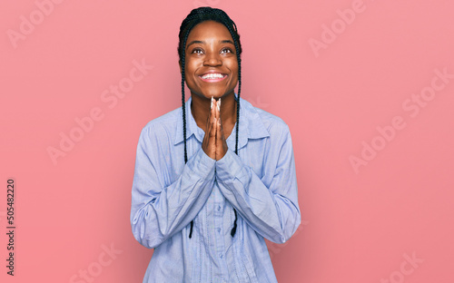 Canvas Young african american woman wearing casual clothes begging and praying with hands together with hope expression on face very emotional and worried