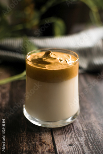 glass of dalgona coffee on dark wooden table