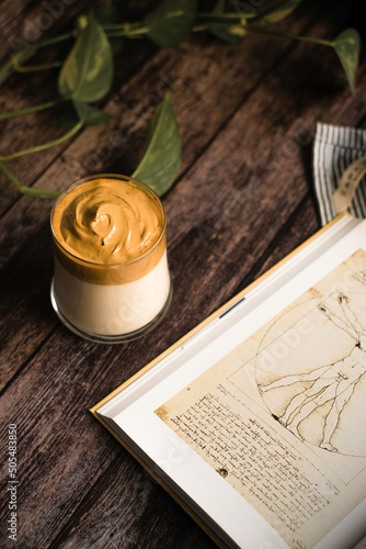 glass of dalgona coffee on dark wooden table