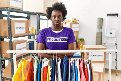 African young woman wearing volunteer t shirt at donations stand skeptic and nervous, frowning upset because of problem. negative person.