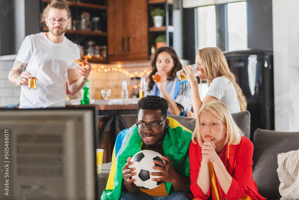 Obraz premium Multicultural friends gathered together to watch the soccer football championship