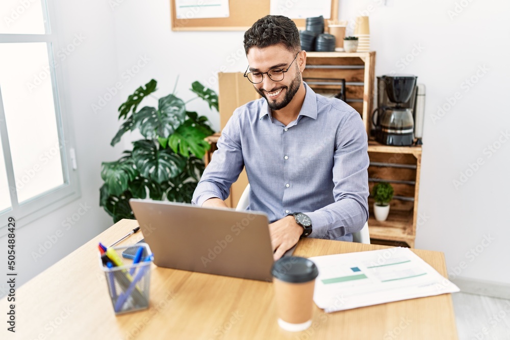 Young arab man smiling confident using laptop working at office Young arab man smiling confident using laptop working at office