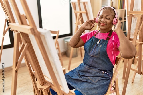 Senior african american woman listening to music drawing at art studio