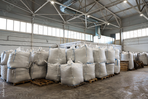 Huge plastic bags with product on pallets at recycling plant